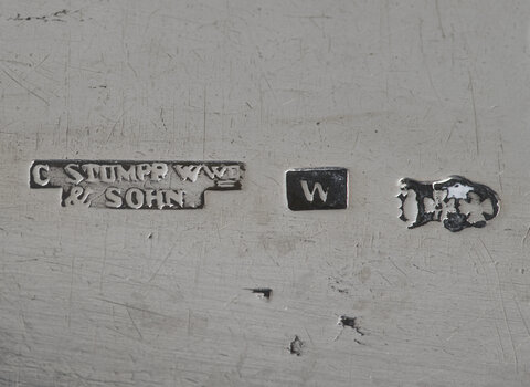 Zdjęcie przedstawia trzy punce na srebrze. Z lewej w dwóch liniach napis "C. Stumpf wwe" i niżej "& Sohn". W środku kwadrat z literą W, po prawej obrócony o 90 stopni w lewo herb Gdańska (korona i pod nią dwa krzyże, wszystkie elementy w równych odstępach). 