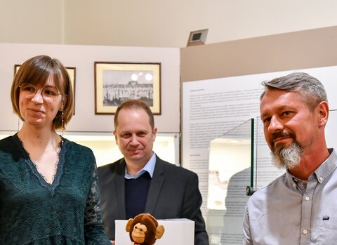 Aleksandra Wlazło, Marek Adamkowicz oraz Ernest Jezionek prezentują małpkę, maskotkę ubraną w dwukolorowy trykot KS Gedania. 