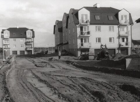 Jedno ze zdjęć przekazanych przez Andrzeja Kowalczyka. Widok na ulicę Borhardta w 1998 roku. Na pierwszym planie droga, w tle dwa budynki mieszkalne. Zdjęcie w odcieniach szarości.     