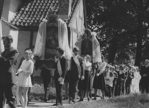procesja Bożego Ciała na Matarni ok. 1970 roku. Na zdjęciu uczestnicy procesji idą wzdłuż białego budynku, najprawdopodobniej kościoła. 