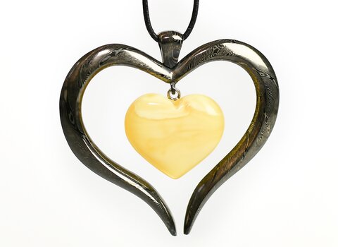 Wisior metalowy w formie serca. W środku bursztynowe serce. 