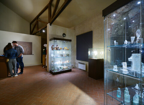 Zdjęcie przedstawia wnętrze Domu Komendanta w Twierdzy Wisłoujście. Po prawej widać trzy szklane gabloty zawierające przedmioty z dawnego wyposażenia pomieszczenia.