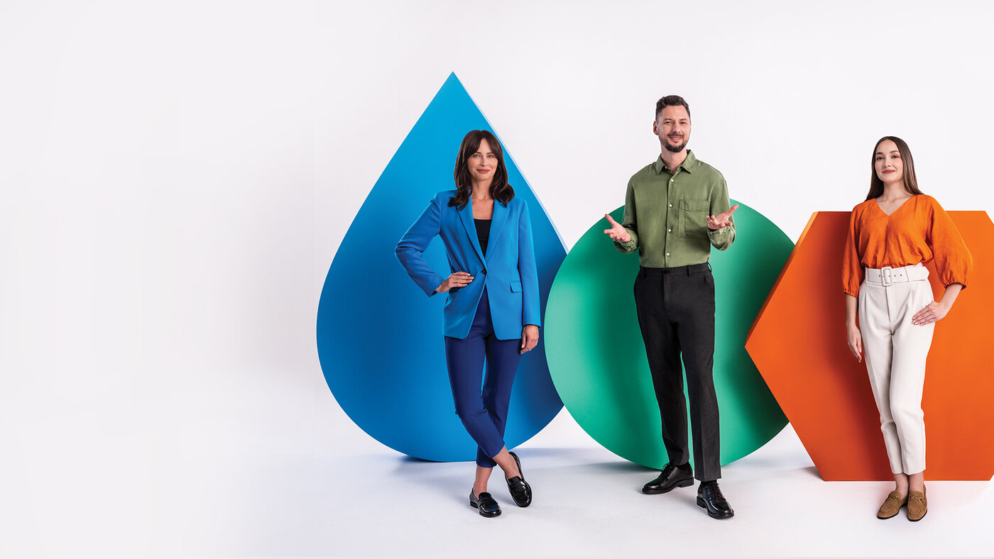 troje ludzi na tle figur symbolizujących 3W – woda to niebieska kropla, wodór to zielone koło, węgiel to pomarańczowy heksagon
