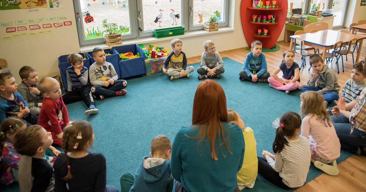 Dzieci w sali przedszkolnej podczas zajęć z wychowawcą
