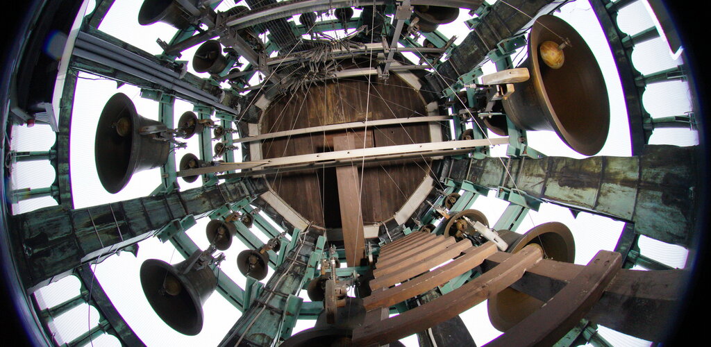 Zdjęcie przedstawia widok od dołu na dzwony carillonu i sklepienie szczytu wieży Ratusza.  